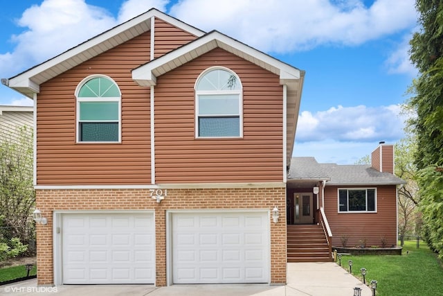 701 N Coolidge Ave, Palatine, IL 60067 - view of front of house featuring an attached garage, driveway, a chimney, and brick siding