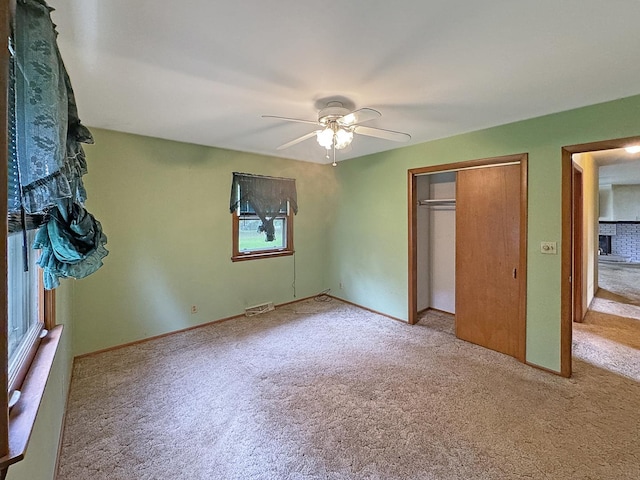 unfurnished bedroom with carpet floors, a ceiling fan, visible vents, and a closet