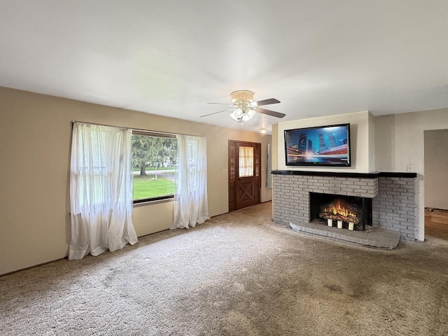 unfurnished living room featuring carpet flooring, a ceiling fan, and a fireplace