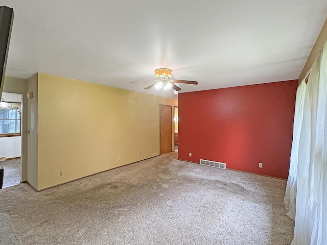 spare room featuring ceiling fan, visible vents, and carpet