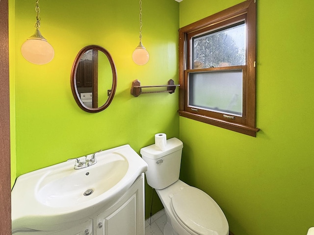 half bathroom featuring vanity and toilet