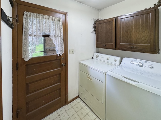 laundry room with light floors, baseboards, washing machine and dryer, and cabinet space