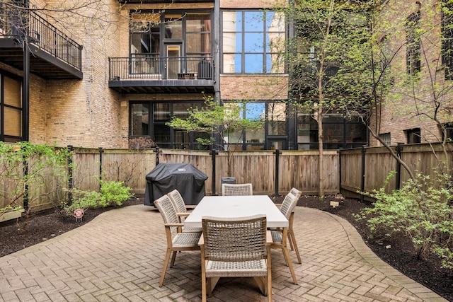 view of patio featuring a fenced backyard, outdoor dining area, and grilling area