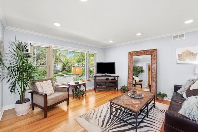 living room featuring light wood finished floors, crown molding, recessed lighting, and baseboards