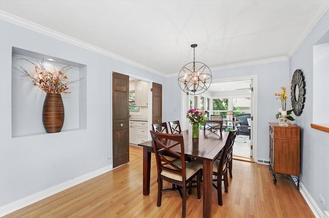 dining area with a chandelier, light wood finished floors, crown molding, and baseboards