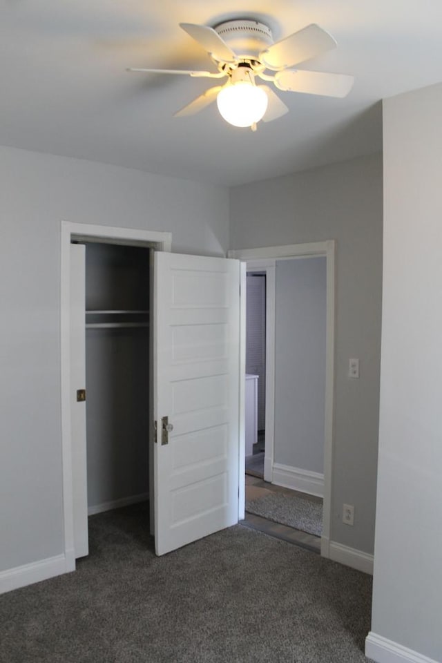 unfurnished bedroom with carpet flooring, baseboards, ceiling fan, and two closets