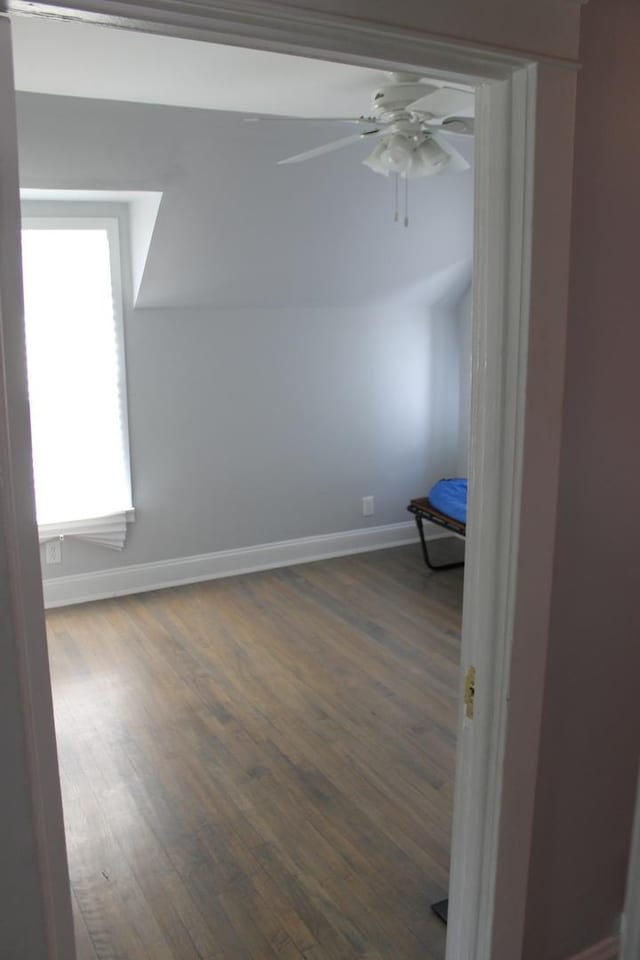 unfurnished living room with beamed ceiling, baseboards, wood-type flooring, and a fireplace