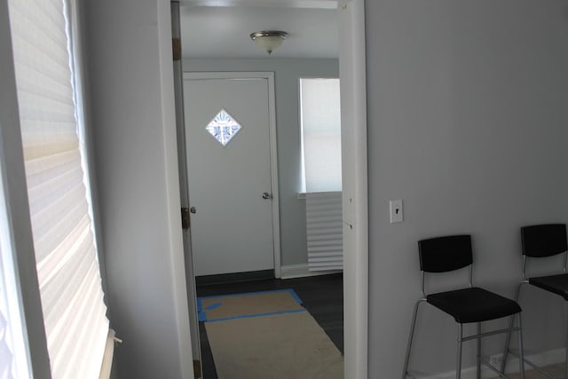 entryway with baseboards and dark wood-style floors