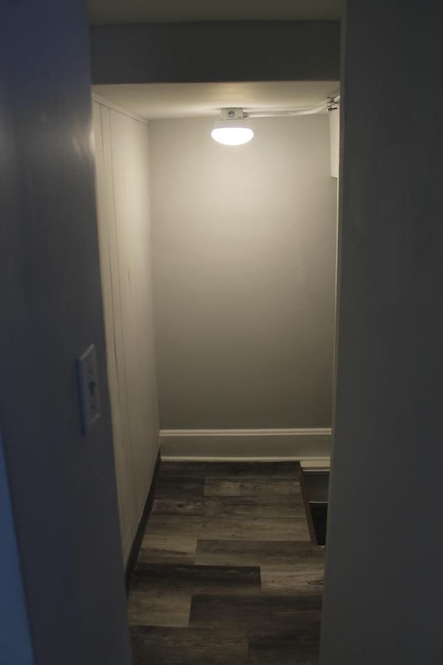 half bathroom with wood finished floors, toilet, vanity, and baseboards