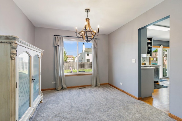 10134 Ashley St, Huntley, IL 60142 - unfurnished dining area featuring a chandelier, carpet flooring, and baseboards