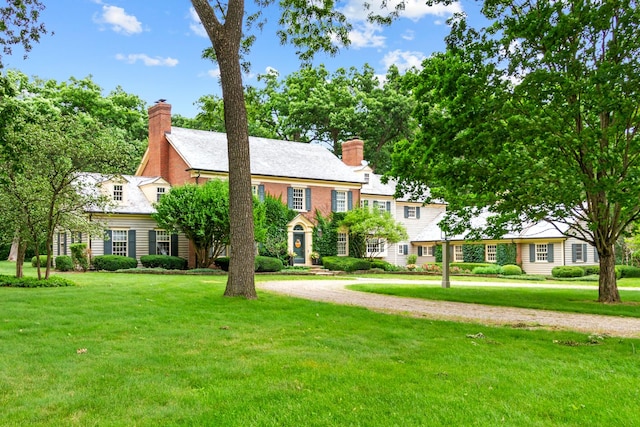 view of front of property featuring a chimney and a front yard