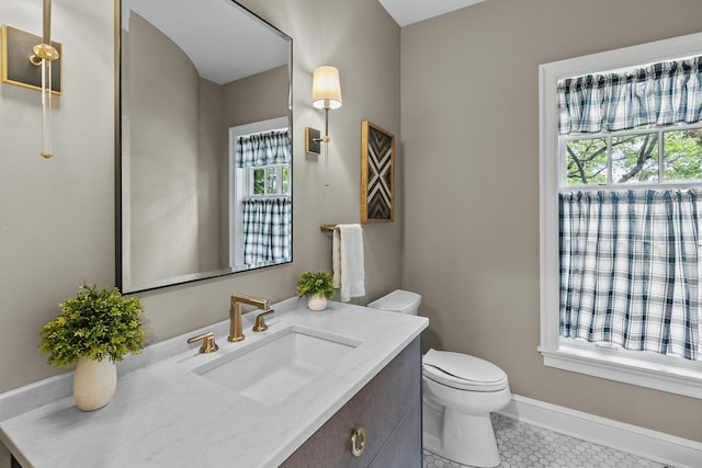 bathroom with tile patterned flooring, toilet, a healthy amount of sunlight, and vanity