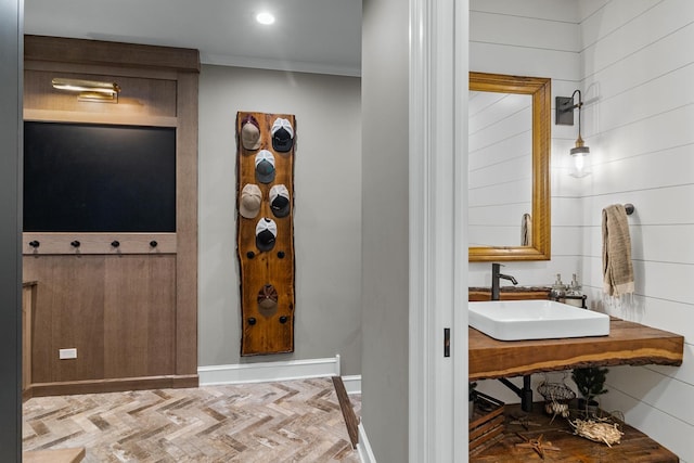 interior space featuring a sink, ornamental molding, baseboards, and recessed lighting