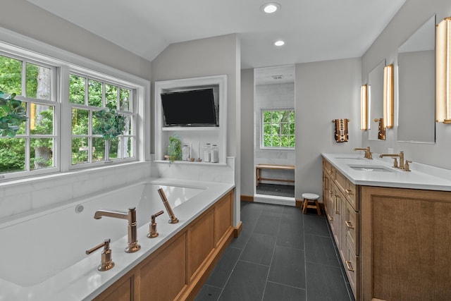 bathroom with double vanity, a garden tub, a sink, tile patterned flooring, and vaulted ceiling