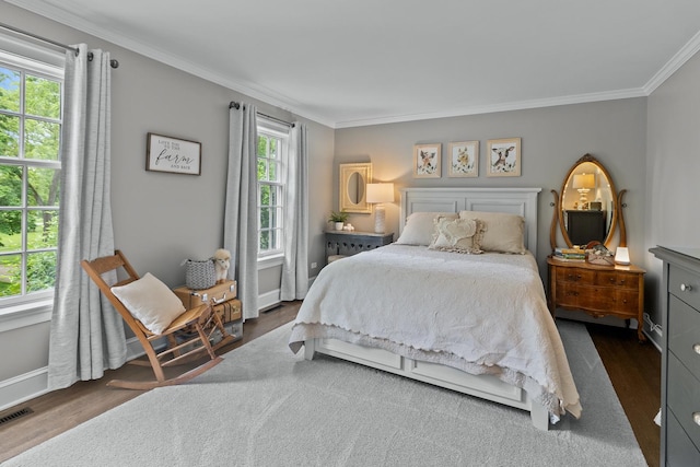 bedroom featuring crown molding, baseboards, dark wood-type flooring, and visible vents