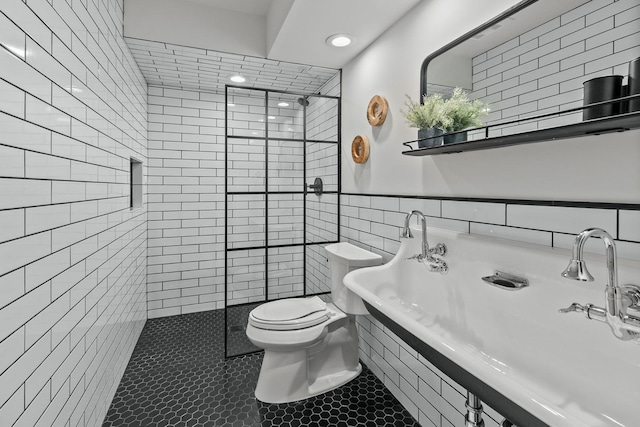 bathroom with tile walls, toilet, tile patterned floors, a walk in shower, and wainscoting
