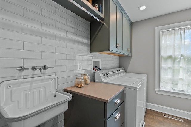 laundry room featuring baseboards, visible vents, dark wood-type flooring, separate washer and dryer, and cabinet space