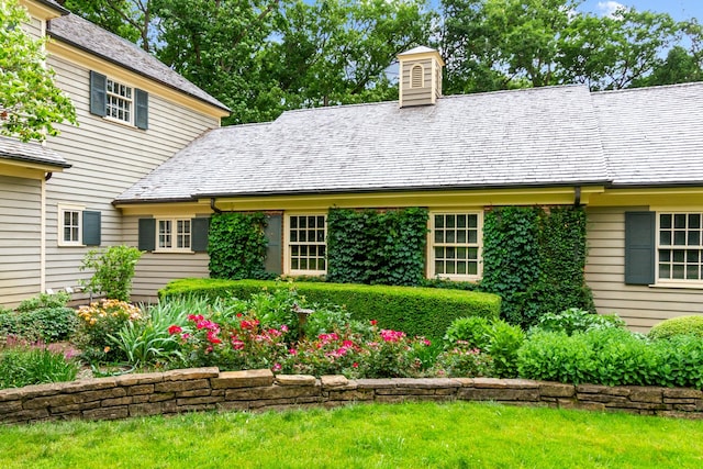 rear view of property with a chimney and a high end roof