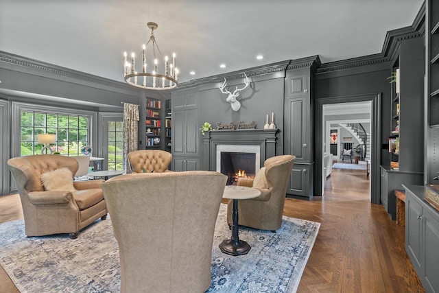 living area featuring recessed lighting, an inviting chandelier, built in shelves, crown molding, and a lit fireplace
