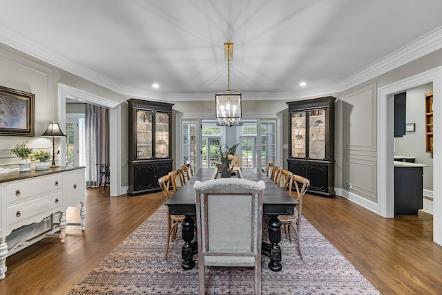 dining space featuring a chandelier, crown molding, and dark wood-style floors