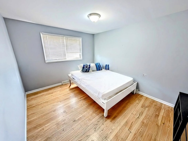 bedroom featuring baseboards and light wood-style flooring