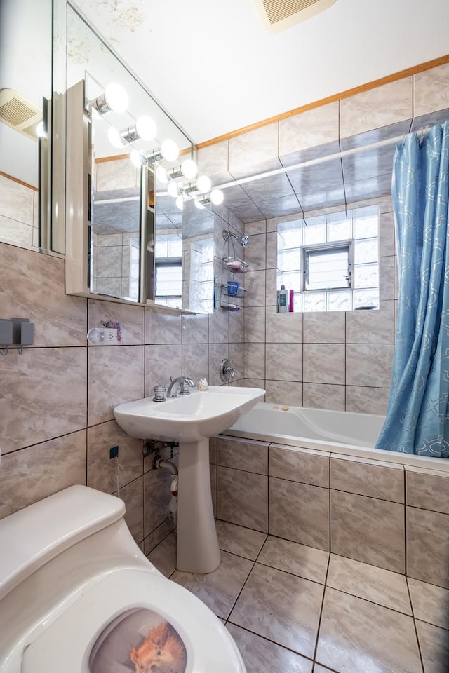 full bathroom with tile walls, visible vents, tiled shower / bath combo, and tile patterned flooring