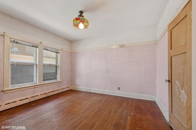 unfurnished room with baseboards, baseboard heating, and wood finished floors