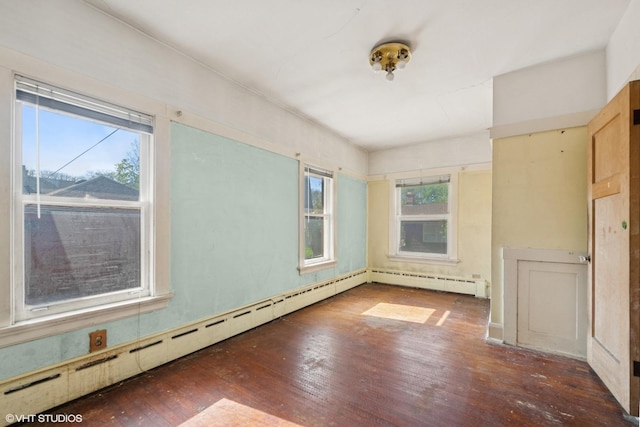 unfurnished room with hardwood / wood-style flooring, a wealth of natural light, and baseboard heating