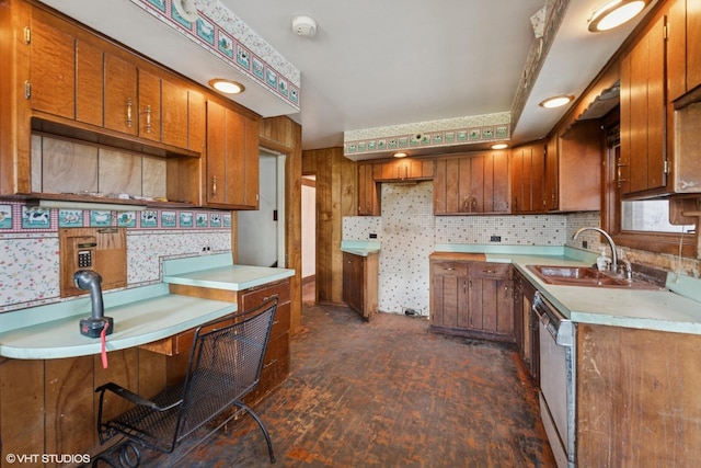 kitchen with dishwasher, a sink, backsplash, brown cabinets, and light countertops