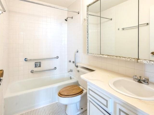 full bathroom featuring washtub / shower combination, vanity, toilet, tile patterned floors, and backsplash