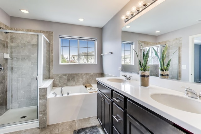 full bathroom featuring a shower stall, a bath, and double vanity