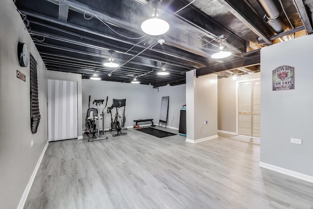 exercise area with wood finished floors and baseboards
