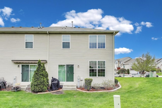rear view of house featuring a yard and entry steps