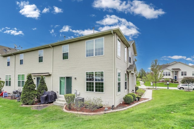 back of house with a lawn and central AC unit