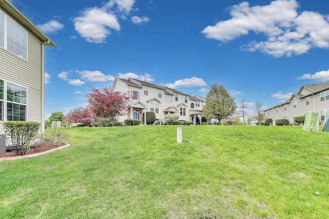 view of green lawn with a residential view