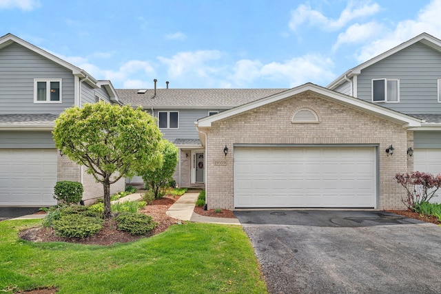 view of front of property featuring brick siding, an attached garage, and driveway