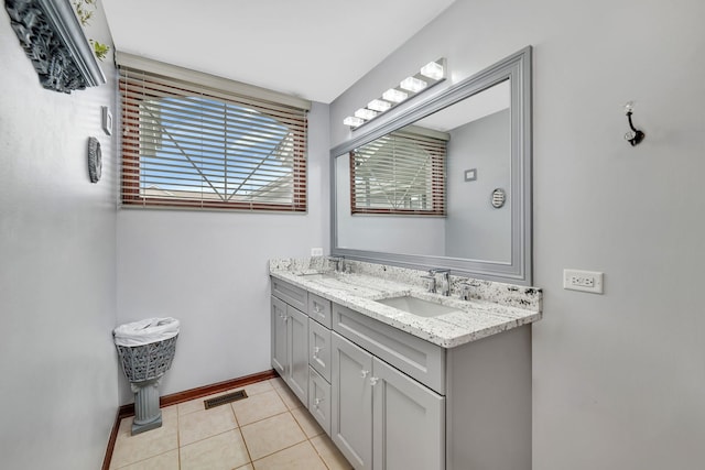 full bath with visible vents, a sink, baseboards, and double vanity