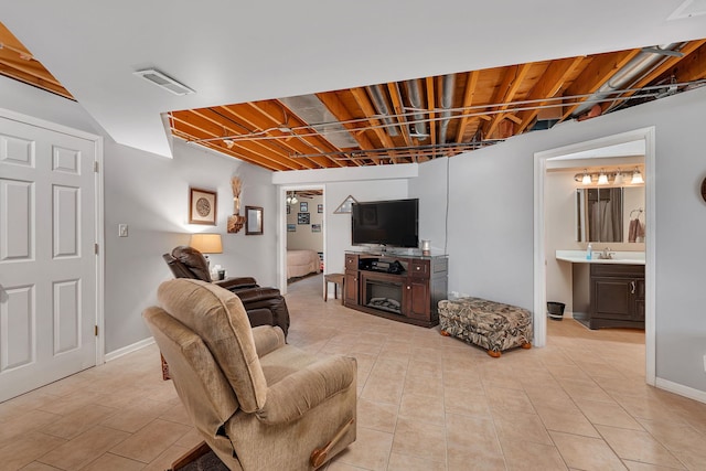 living area featuring baseboards, light tile patterned flooring, and visible vents