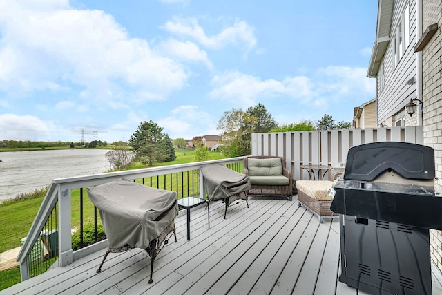 deck featuring grilling area, a water view, and a yard
