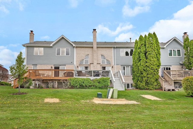rear view of property featuring a wooden deck, a yard, and stairway