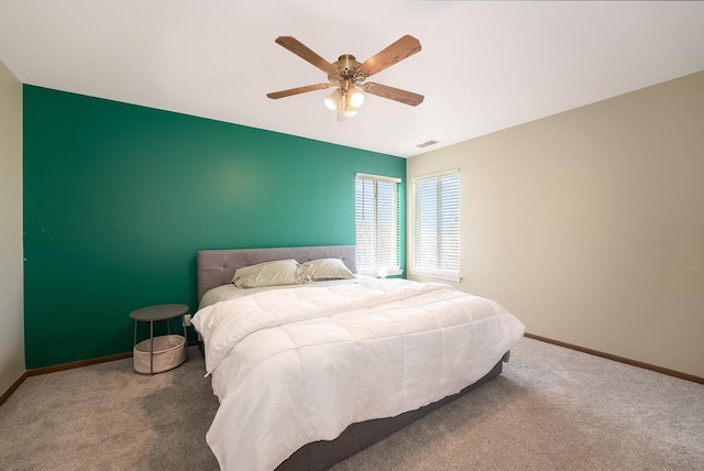 carpeted bedroom with baseboards, ceiling fan, and visible vents