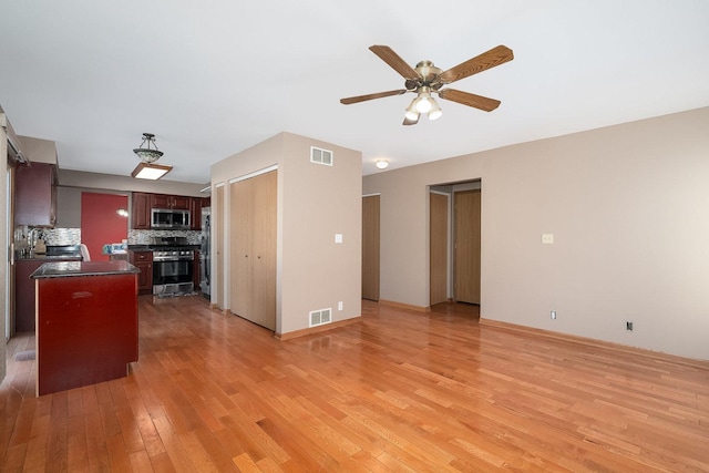kitchen featuring visible vents, light wood finished floors, dark countertops, and stainless steel appliances