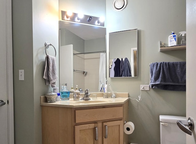 full bath featuring toilet, a shower with shower curtain, and vanity
