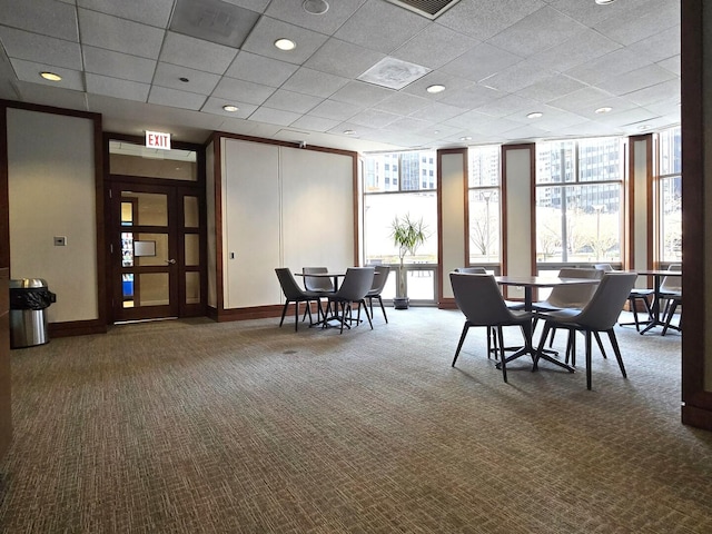 carpeted dining space with a wall of windows, baseboards, and a wealth of natural light