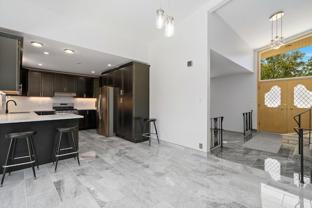 13001 S Westgate Dr, Palos Heights, IL 60463 - kitchen featuring stainless steel appliances, light countertops, a high ceiling, a sink, and a breakfast bar area