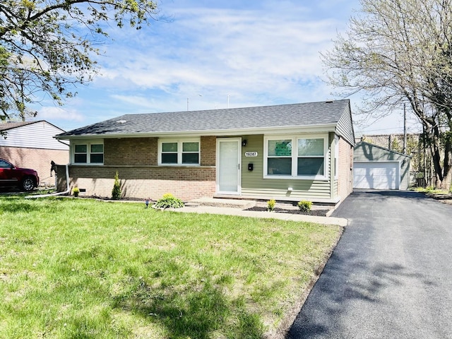 single story home featuring roof with shingles, a garage, brick siding, an outdoor structure, and a front lawn