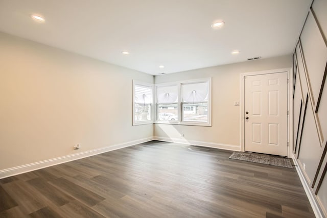 interior space featuring recessed lighting, baseboards, dark wood finished floors, and visible vents