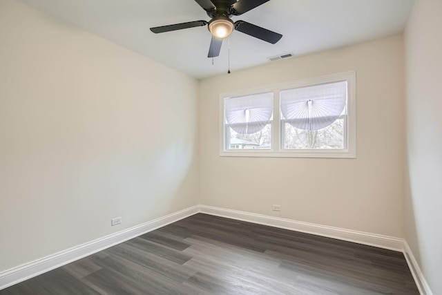 empty room with a ceiling fan, baseboards, visible vents, and dark wood finished floors