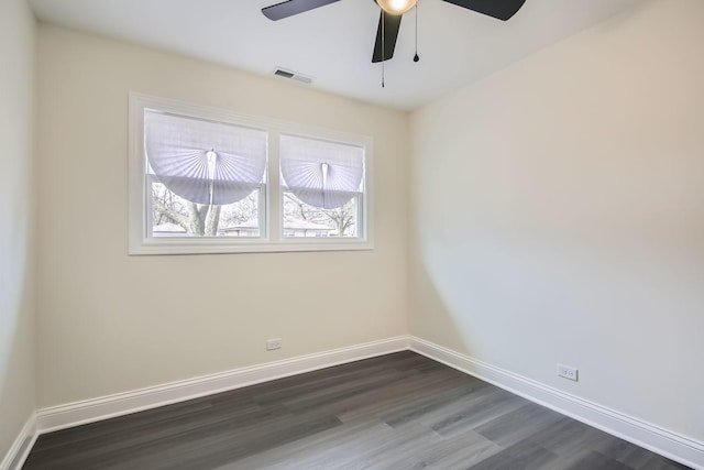 spare room featuring baseboards, ceiling fan, dark wood-style floors, and visible vents