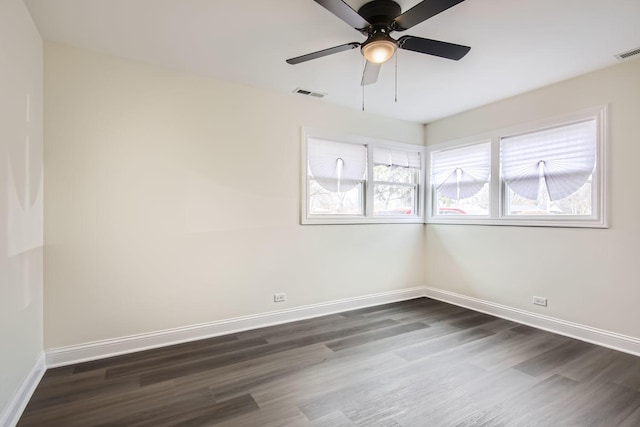 empty room featuring a ceiling fan, baseboards, visible vents, and dark wood finished floors